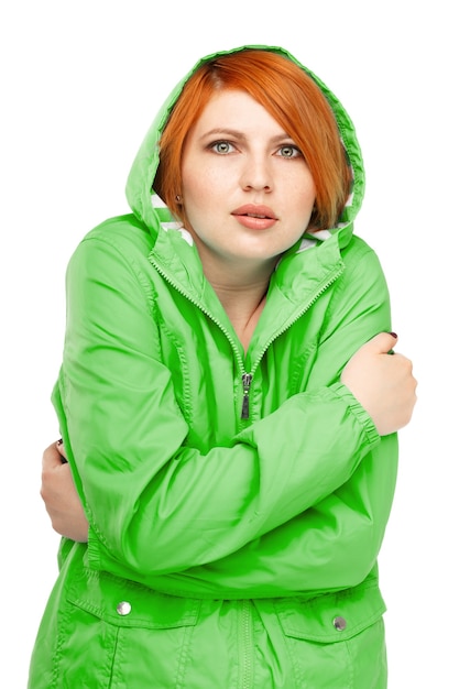 Foto retrato de una niña en una chaqueta con un temblor de frío aislado en blanco