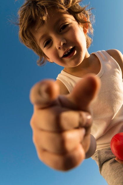 Foto retrato de una niña con el cielo azul en un ángulo bajo