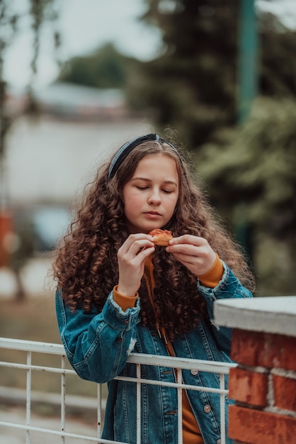 Retrato de una niña comiendo pizza en un almuerzo en la escuela durante la apertura gradual después del cierre de la pandemia enfoque selectivo foto de alta calidad