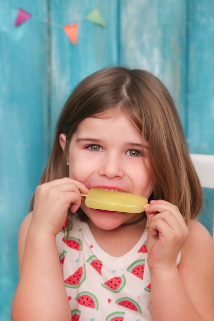 Retrato de niña comiendo polo de hielo de limón