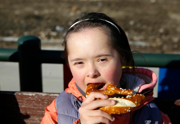 Foto retrato de niña comiendo pretzel