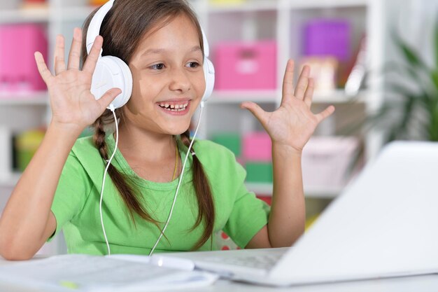 Foto retrato de niña concentrada con laptop estudiando en casa