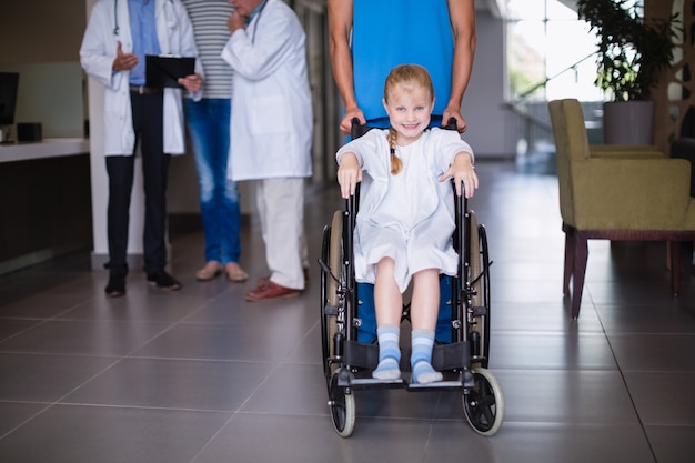 Retrato de niña discapacitada sonriente en silla de ruedas