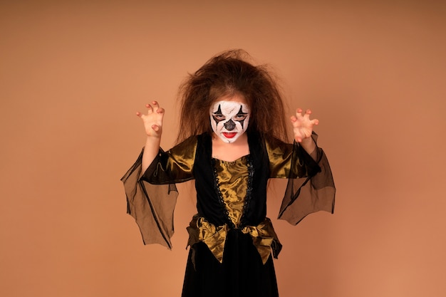 Foto retrato de una niña en un disfraz de bruja, preparándose para la fiesta de halloween