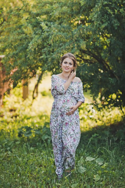 Foto retrato de una niña embarazada caminando en el jardín de verano 1650