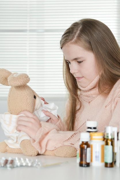 Retrato de una niña enferma que toma medicamentos en casa