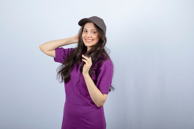 Retrato de niña de entrega en uniforme púrpura de pie y posando. foto de alta calidad