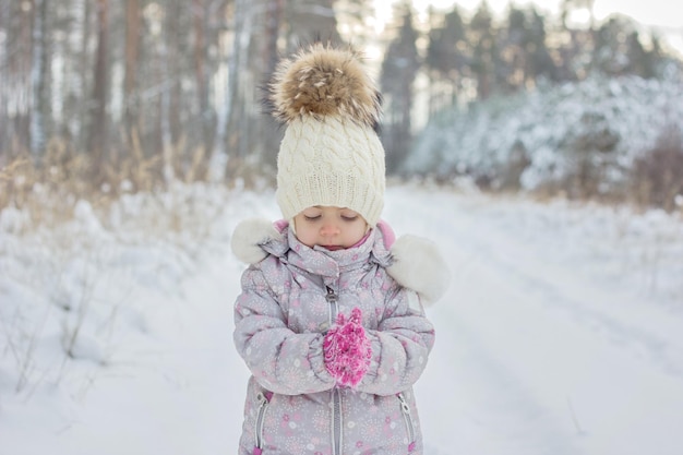 Retrato de niña es bosque nevado en invierno