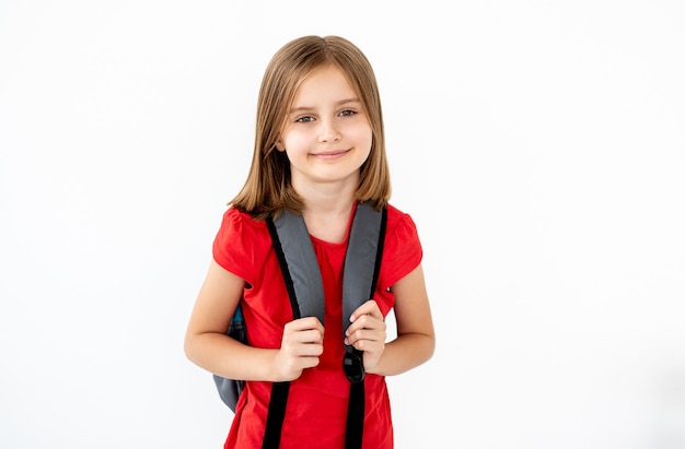 Retrato de niña de la escuela primaria con mochila aislado en blanco