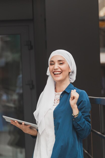 Retrato de una niña estudiante árabe sosteniendo una tableta mujer de negocios árabe en hijab sosteniendo una tableta en