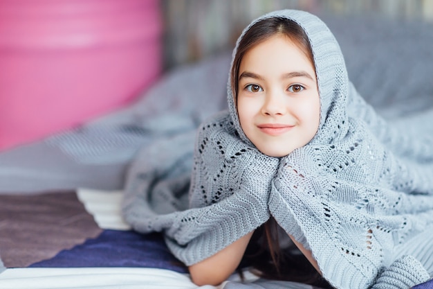 Foto retrato de niña feliz acostada en la cama