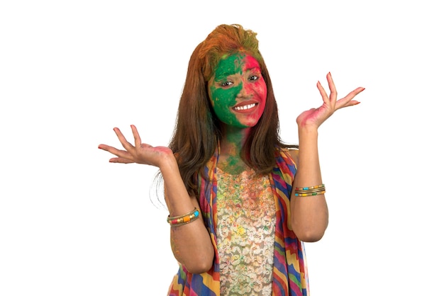 Retrato de una niña feliz con una cara colorida en el festival de color Holi en blanco