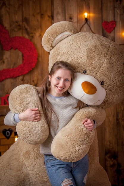 Retrato de una niña feliz con un enorme oso