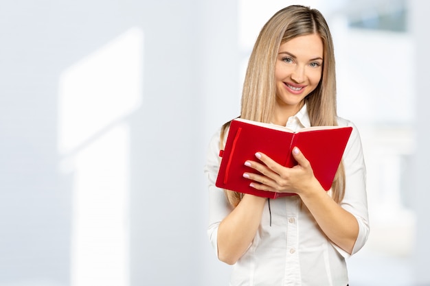 Retrato de una niña feliz estudiante o mujer con libros en la biblioteca