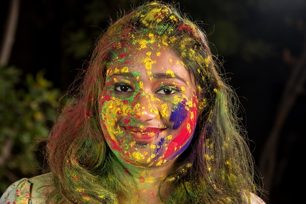 Retrato de una niña feliz en el festival de colores Holi. Chica posando y celebrando la fiesta de los colores.