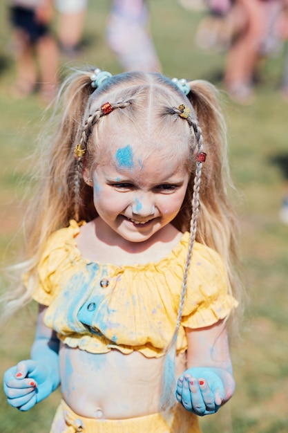 Retrato de una niña feliz en el festival de colores de Holi Una niña preescolar linda en el festival del color de Holi