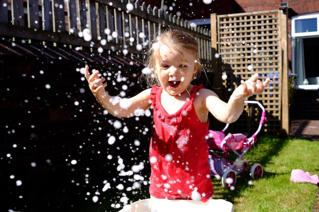 Retrato de una niña feliz jugando en el agua
