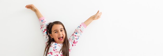 retrato de una niña feliz en la pared blanca