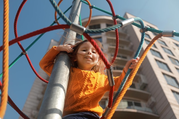 Retrato de una niña feliz en un patio moderno en el patio de un complejo residencial