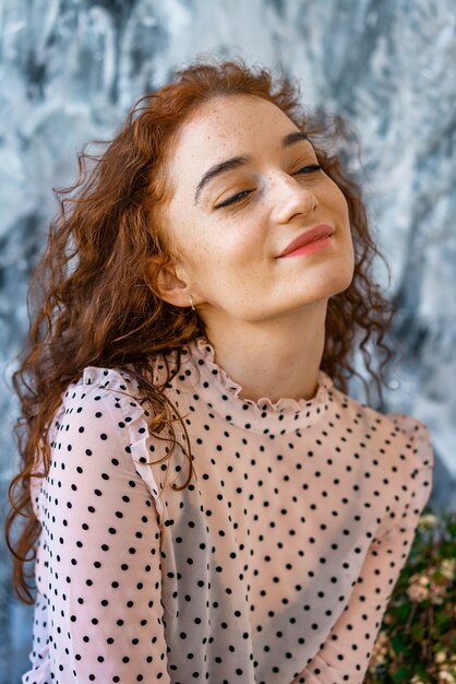 Retrato de una niña feliz con el pelo rojo, emociones positivas en su cara