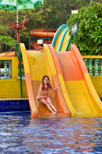 Retrato de una niña feliz en tobogán de agua