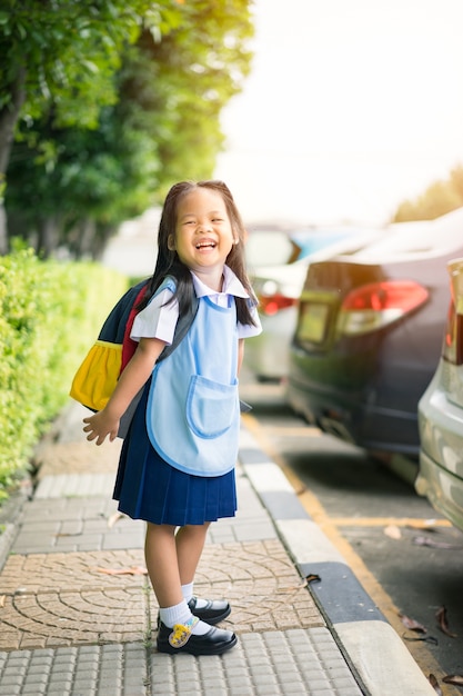 Retrato de niña feliz con uniforme escolar tailandés de pie en el parque, lista para regresar a la escuela