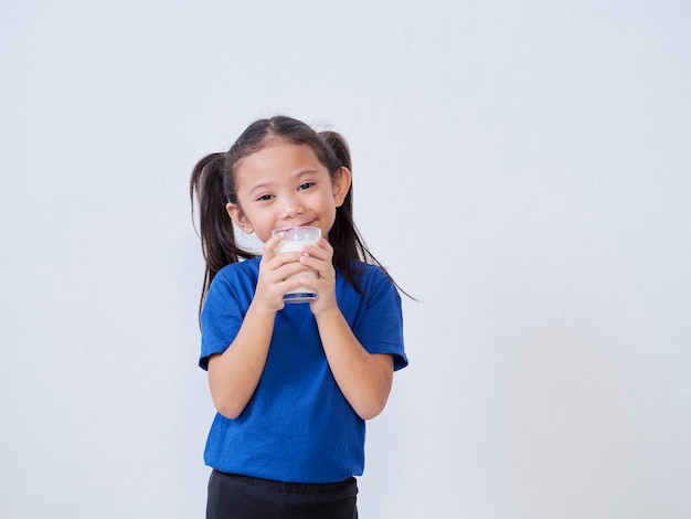 Retrato de niña feliz con vaso de leche a la luz