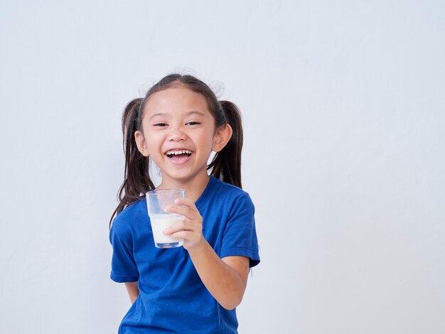 Retrato de niña feliz con vaso de leche a la luz