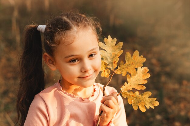 Retrato de una niña en el fondo del parque de otoño.