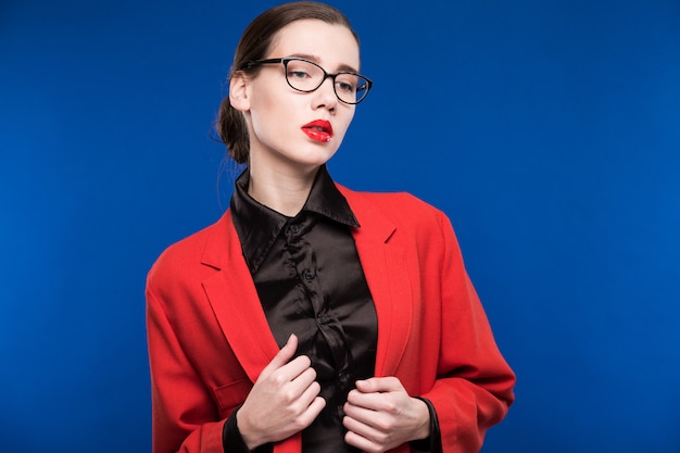 Retrato de una niña con gafas y una chaqueta roja