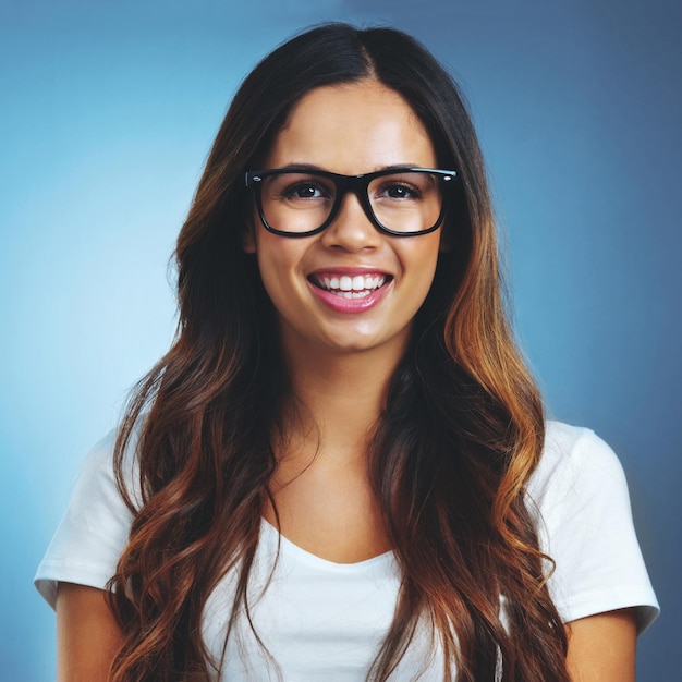 Retrato de niña y gafas en el estudio para optometría visión clara y bienestar de la vista con felicidad Mujer fondo azul y receta para enfermedades de la superficie ocular gafas y cuidado ocular