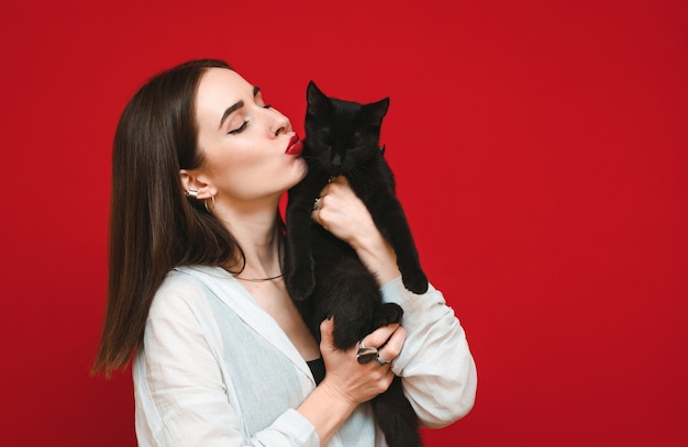 Retrato de una niña con un gato en sus brazos