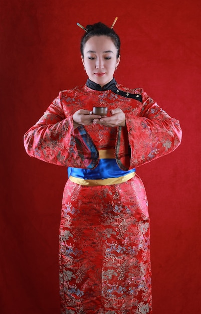 Foto retrato de una niña geisha sobre un fondo rojo.