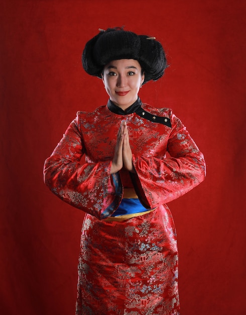 Retrato de una niña geisha sobre un fondo rojo.