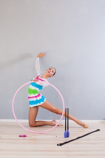 Retrato de niña gimnasta flexible con conchas de gimnasia