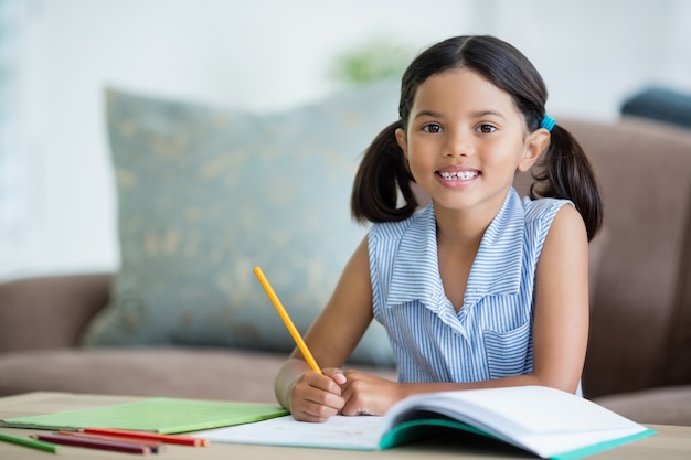 Retrato de niña haciendo su tarea en la sala de estar