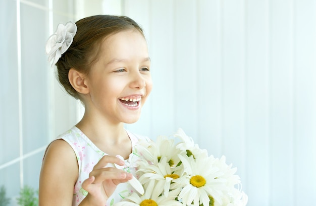 Retrato de niña hermosa con flores dasies