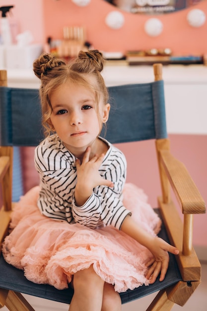 Retrato de una niña hermosa con un peinado elegante en un salón de belleza