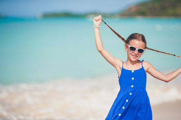 Retrato de niña hermosa en la playa bailando