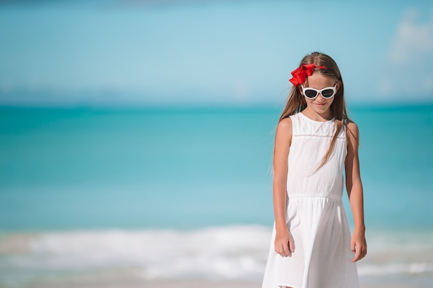 Retrato de niña hermosa en la playa bailando