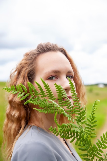 Retrato de niña con hoja de helecho verde