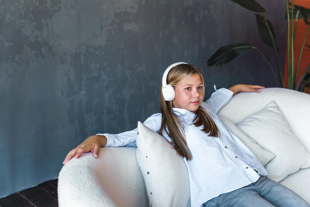 retrato, de, un, niña joven, con, auriculares, en, un, fondo gris