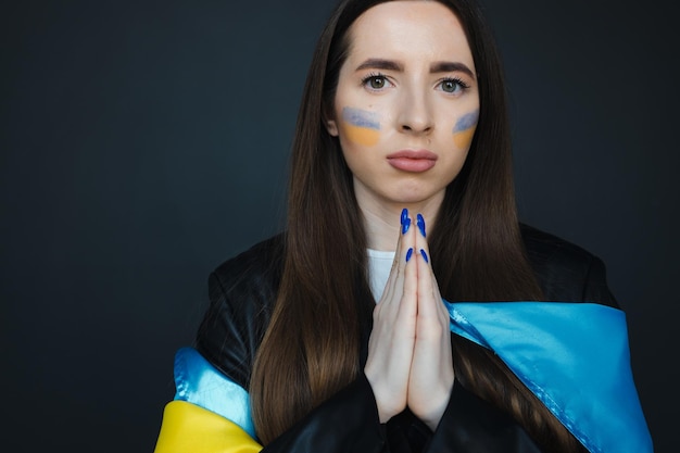 retrato, de, niña joven, con, azul y amarillo, bandera ucraniana, en, ella, mejilla, en, fondo negro