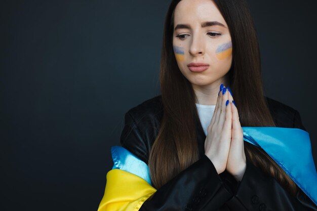 retrato, de, niña joven, con, azul y amarillo, bandera ucraniana, en, ella, mejilla, en, fondo negro