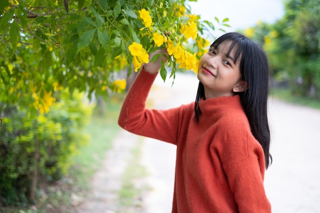 retrato, niña joven, con, flores amarillas, niña asiática