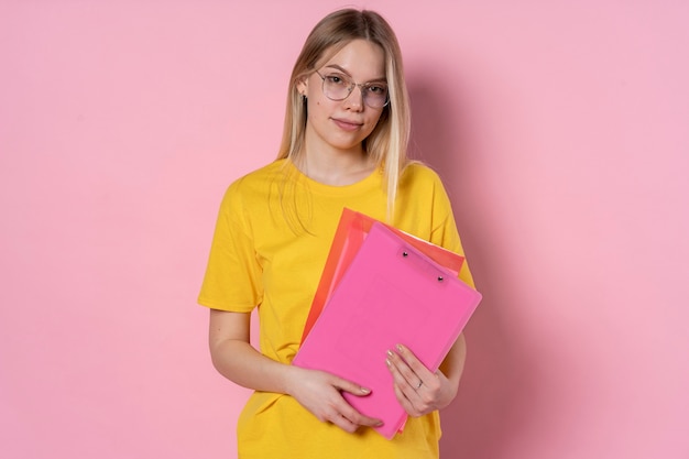 Foto retrato, de, un, niña joven, llevando gafas, y, tenencia, ella, carpeta