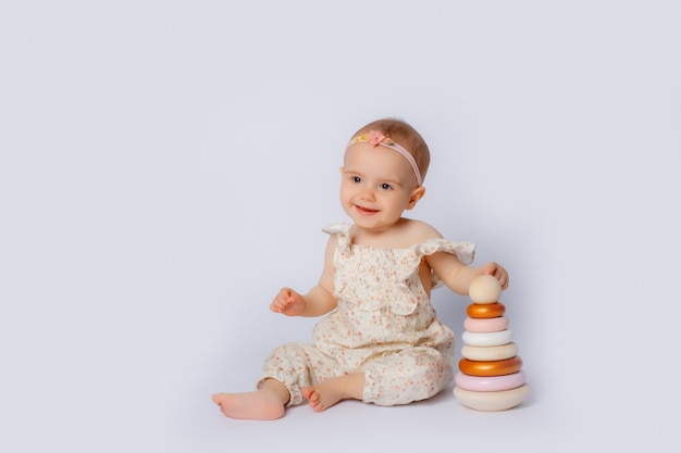 Retrato de niña jugando con platos de juguetes de madera en blanco