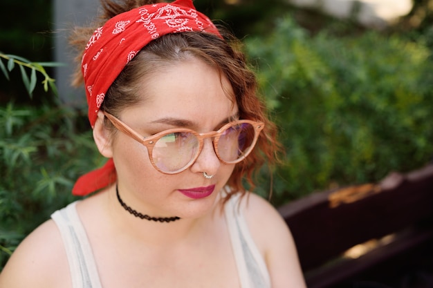 Retrato de niña lesbiana en pañuelo rojo y gafas