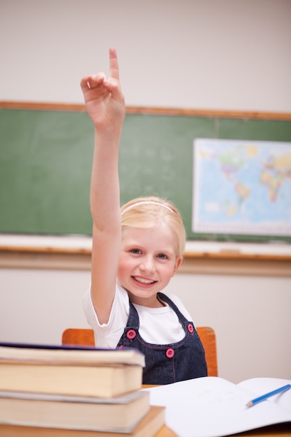 Retrato de una niña levantando su mano