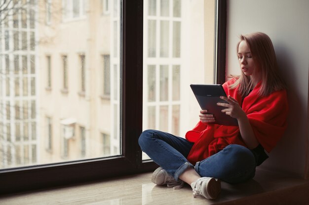 Retrato de una niña leyendo un libro electrónico.